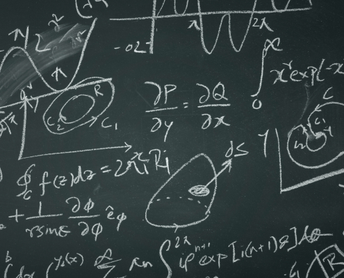 A chalkboard filled with complex mathematical equations, graphs, and diagrams, including integrals, derivatives, vectors, and plotted curves, all written in white chalk.