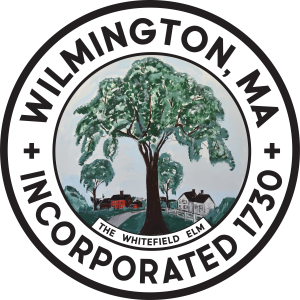 Wilmington Color Seal 2026 A circular seal with Wilmington, MA Incorporated 1730 around an illustration of a large elm tree, houses, and the words The Whitefield Elm at the bottom.