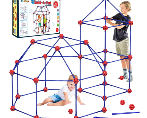 Two children play with a blue and red fort-building kit, constructing a dome and tower structure. The toy packaging is shown in the background with assembly diagrams.